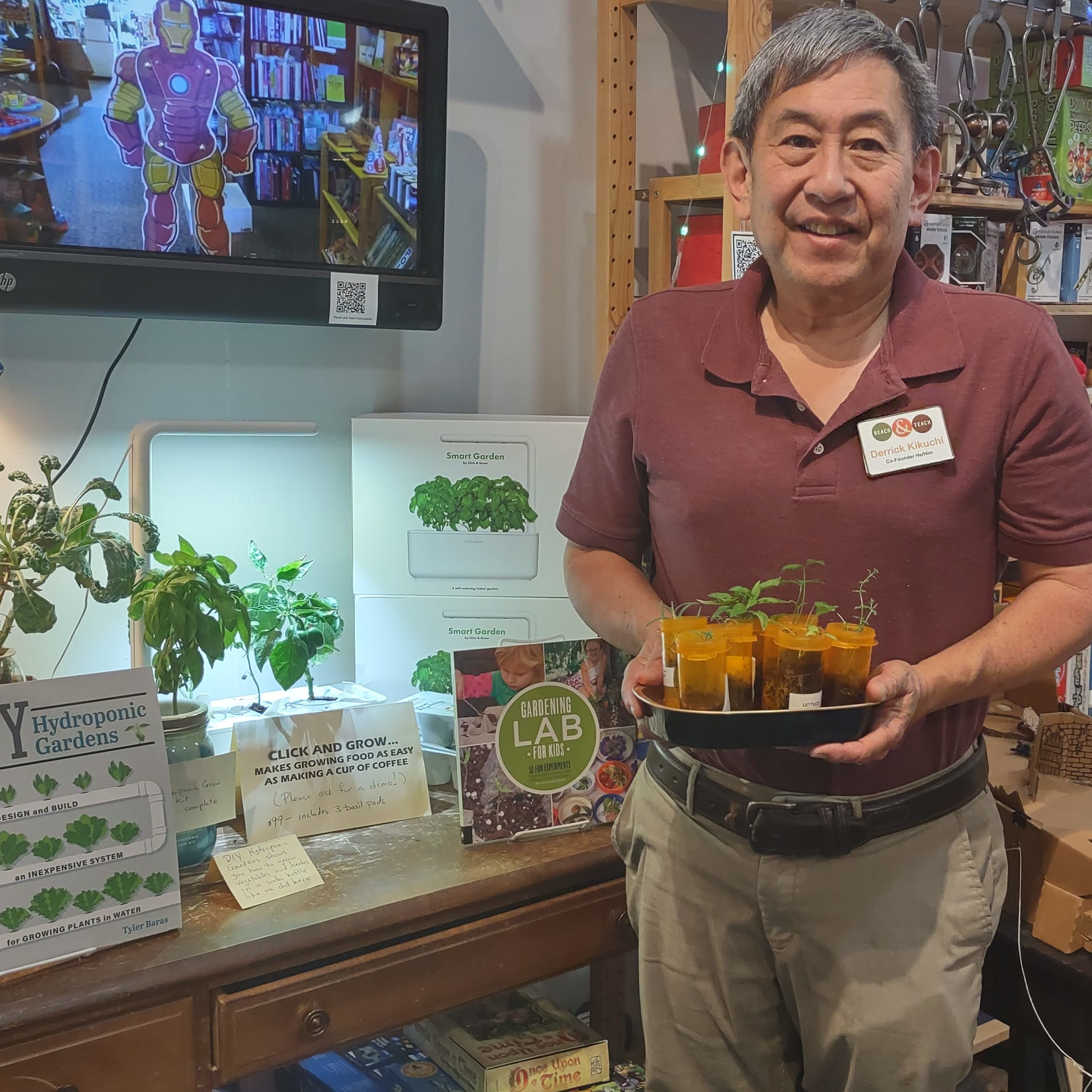 Derrick Kikuchi holding plant seedlings from the Reach and Teach Garden Project